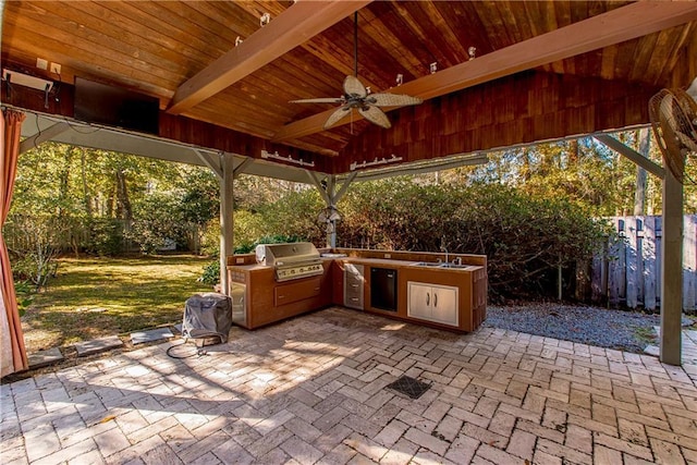 view of patio / terrace featuring ceiling fan, an outdoor kitchen, grilling area, and sink