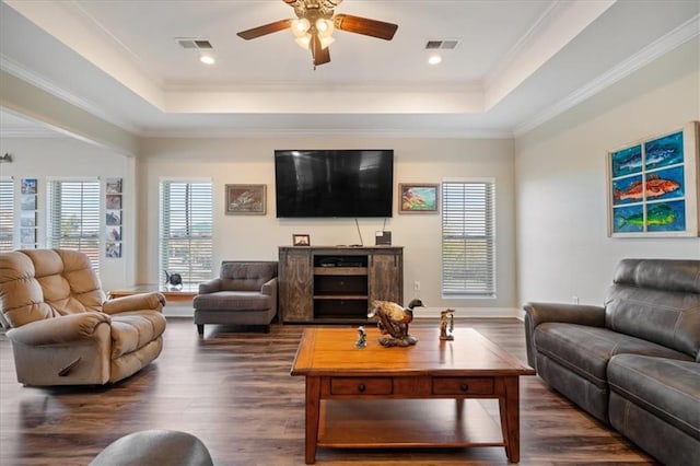 living room with crown molding, ceiling fan, dark hardwood / wood-style flooring, and a tray ceiling