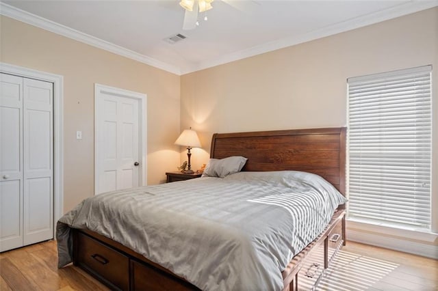 bedroom with crown molding, light hardwood / wood-style flooring, and ceiling fan