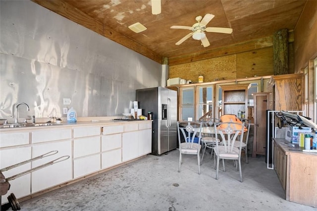 kitchen with stainless steel fridge with ice dispenser, white cabinetry, sink, ceiling fan, and wood ceiling