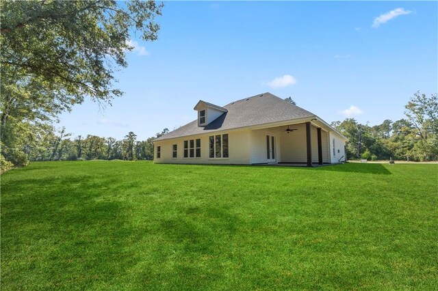 back of house featuring a lawn and ceiling fan