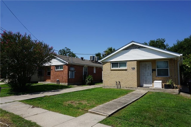 view of front of house featuring cooling unit and a front lawn