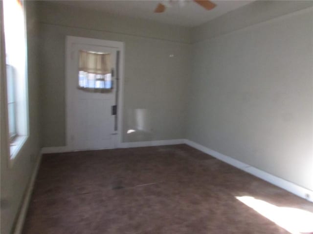 carpeted spare room featuring ceiling fan and a wealth of natural light