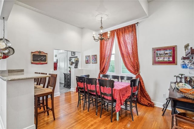 dining space featuring a notable chandelier and light wood-type flooring