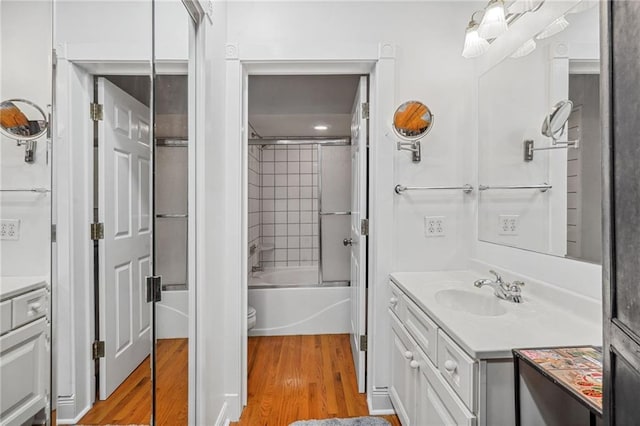 full bathroom with vanity, hardwood / wood-style flooring, enclosed tub / shower combo, and toilet