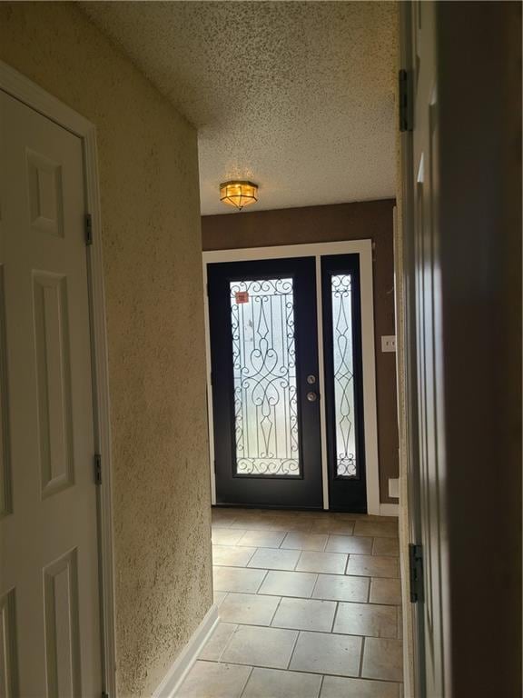 entrance foyer featuring light tile floors and a textured ceiling