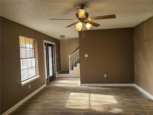 spare room featuring plenty of natural light, ceiling fan, and a textured ceiling