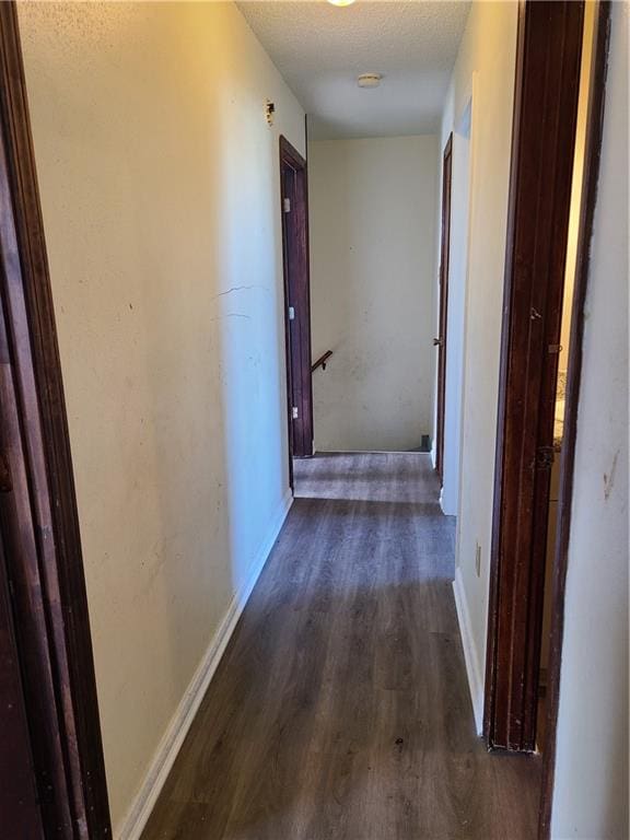 hall with dark hardwood / wood-style flooring and a textured ceiling