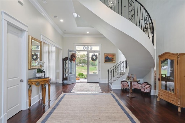 entrance foyer featuring ornamental molding, dark wood-type flooring, and a high ceiling