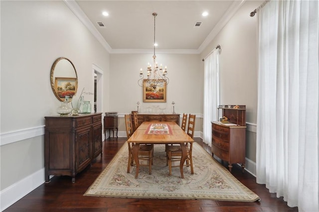 dining space with dark wood-type flooring, crown molding, and an inviting chandelier