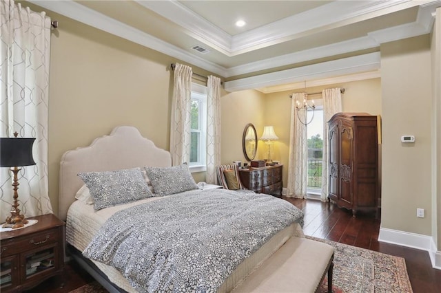 bedroom featuring ornamental molding, dark wood-type flooring, a raised ceiling, and a notable chandelier