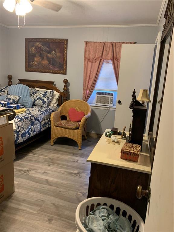 5978 Perryman Ln, Osyka, MS 39657 - bedroom featuring light wood-type flooring, cooling unit, ornamental molding, and a ceiling fan