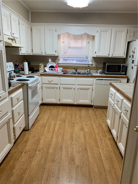 5978 Perryman Ln, Osyka, MS 39657 - kitchen with white cabinets, under cabinet range hood, a sink, and white appliances