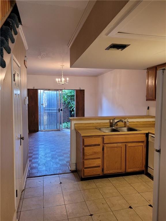 kitchen with decorative light fixtures, a chandelier, light tile floors, white appliances, and sink