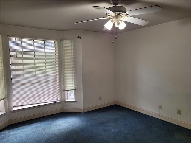 empty room featuring dark colored carpet and ceiling fan