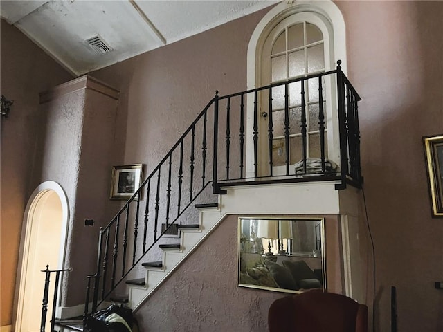 stairs featuring a towering ceiling