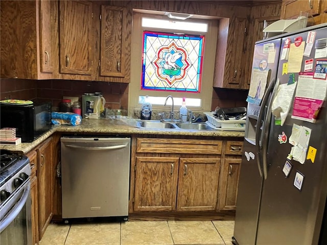 kitchen featuring sink, light tile floors, and stainless steel appliances