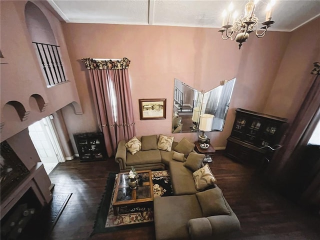 living room featuring crown molding, dark hardwood / wood-style floors, a chandelier, and a towering ceiling