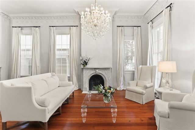 living room with crown molding, dark hardwood / wood-style floors, and an inviting chandelier