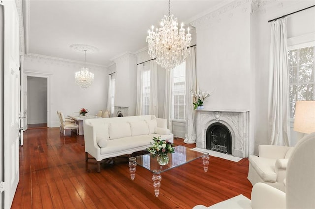 living room featuring an inviting chandelier, dark hardwood / wood-style floors, and ornamental molding