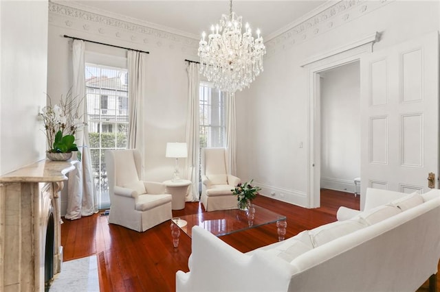 living room featuring dark hardwood / wood-style flooring, a notable chandelier, and ornamental molding