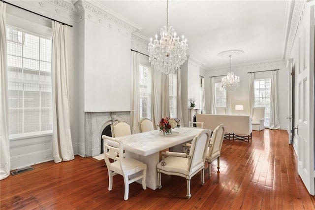 dining room featuring a notable chandelier, dark wood-type flooring, and ornamental molding