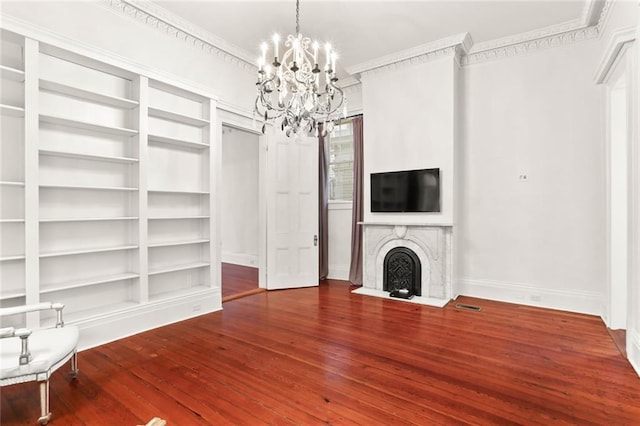 unfurnished living room with crown molding, dark hardwood / wood-style floors, and a notable chandelier