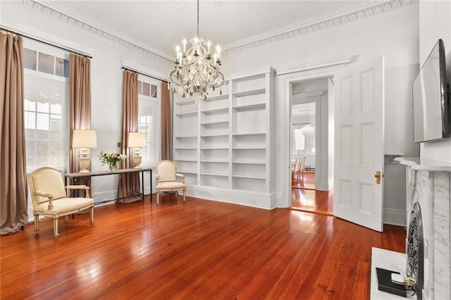 unfurnished room with crown molding, a chandelier, dark hardwood / wood-style floors, and a healthy amount of sunlight