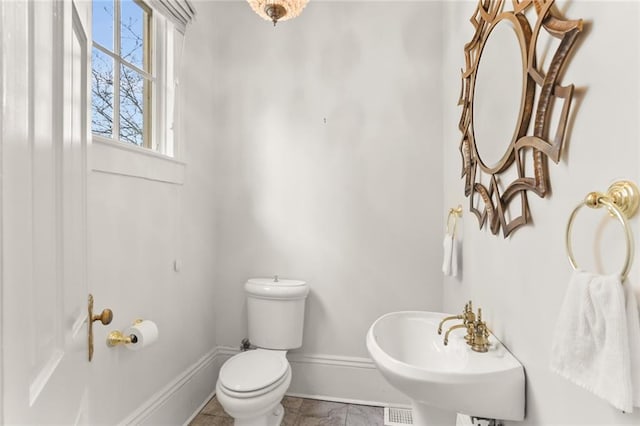 bathroom featuring toilet, tile floors, and sink