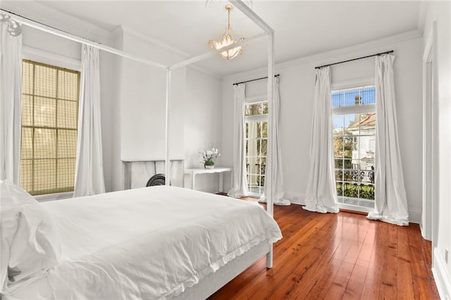 bedroom featuring an inviting chandelier, dark hardwood / wood-style flooring, and ornamental molding