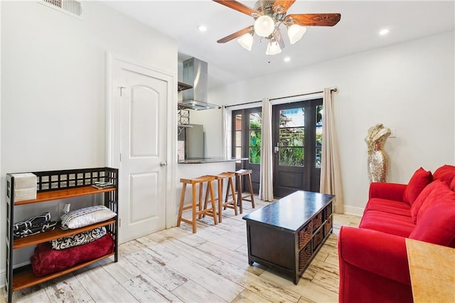 living room featuring ceiling fan and light hardwood / wood-style flooring