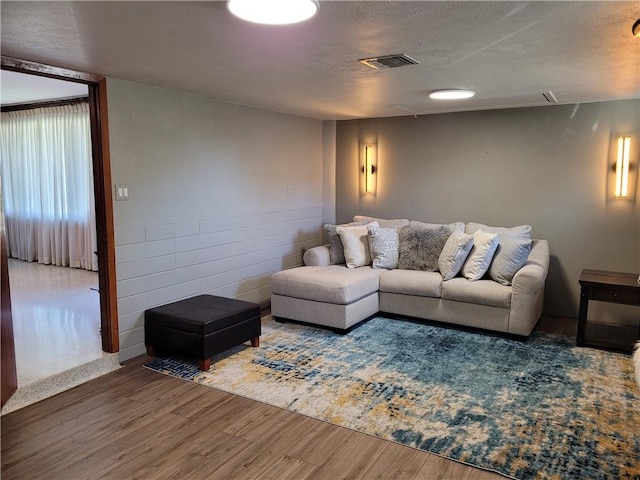 living room with a textured ceiling and dark wood-type flooring