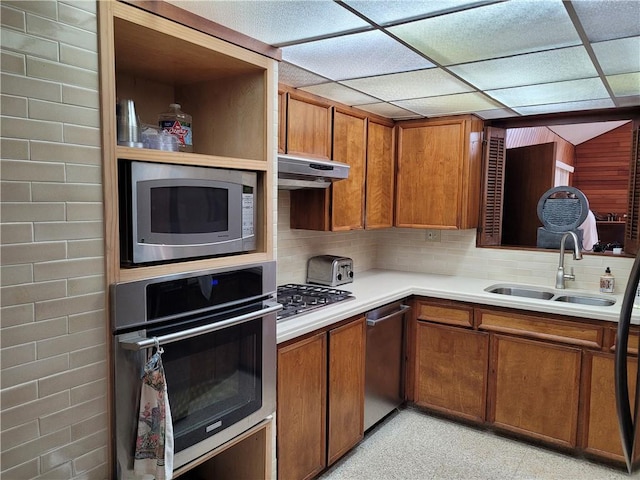 kitchen featuring tasteful backsplash, stainless steel appliances, a drop ceiling, and sink