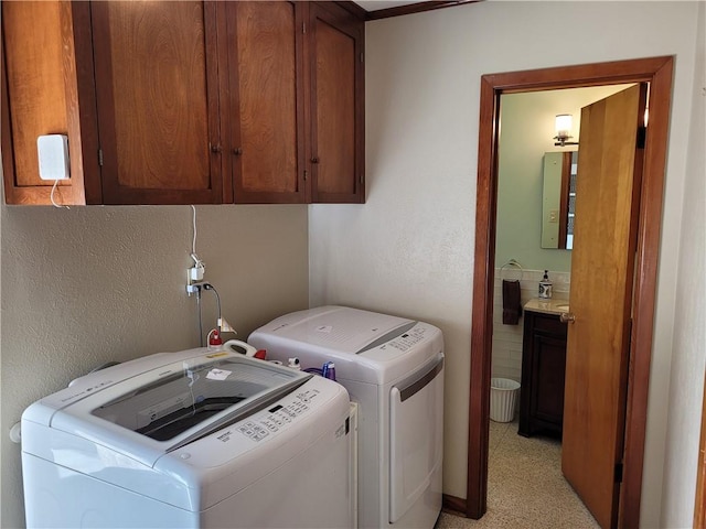 washroom featuring washing machine and clothes dryer, cabinets, and light carpet