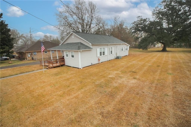 back of property featuring a wooden deck and a lawn