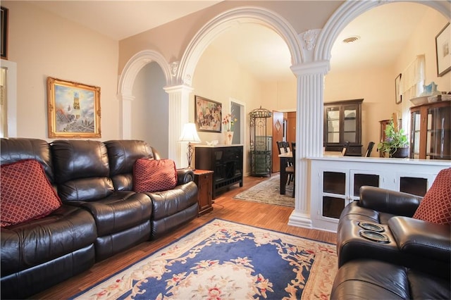 living room with light hardwood / wood-style flooring and ornate columns