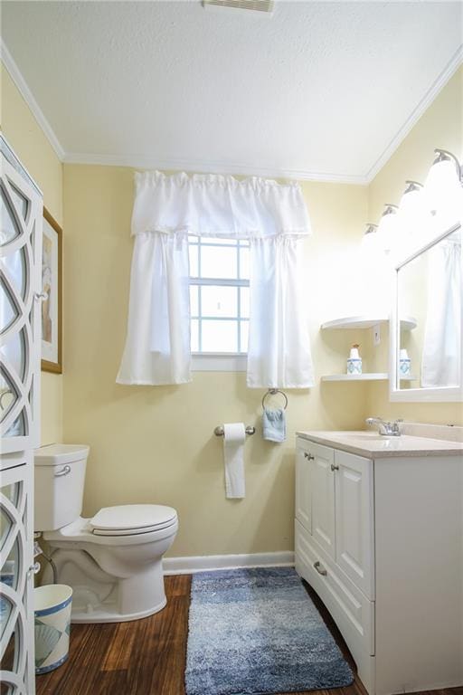 bathroom featuring oversized vanity, toilet, ornamental molding, and hardwood / wood-style floors