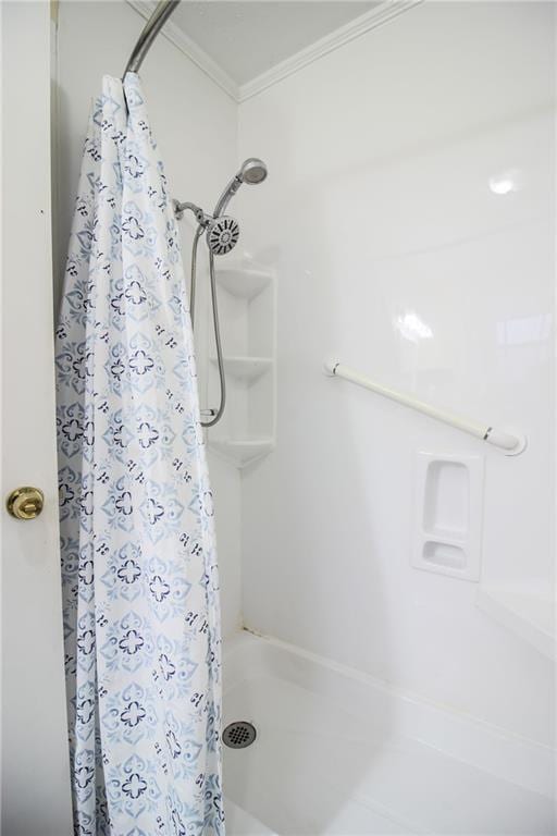 bathroom with crown molding and walk in shower