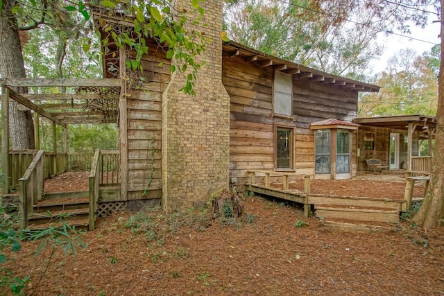 rear view of property with a pergola and a deck