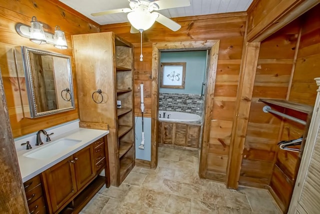 bathroom with ceiling fan, a bath to relax in, tile floors, wood walls, and large vanity