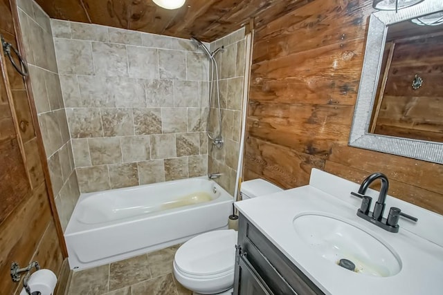 full bathroom featuring wooden walls, oversized vanity, toilet, and tiled shower / bath combo