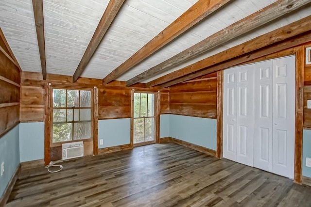 interior space featuring a healthy amount of sunlight, wooden walls, wood-type flooring, and vaulted ceiling with beams