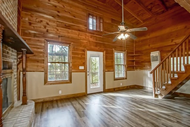 foyer entrance featuring wood-type flooring, wood walls, high vaulted ceiling, wood ceiling, and ceiling fan