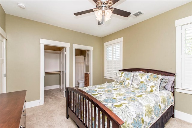 carpeted bedroom featuring ceiling fan, a closet, and ensuite bathroom