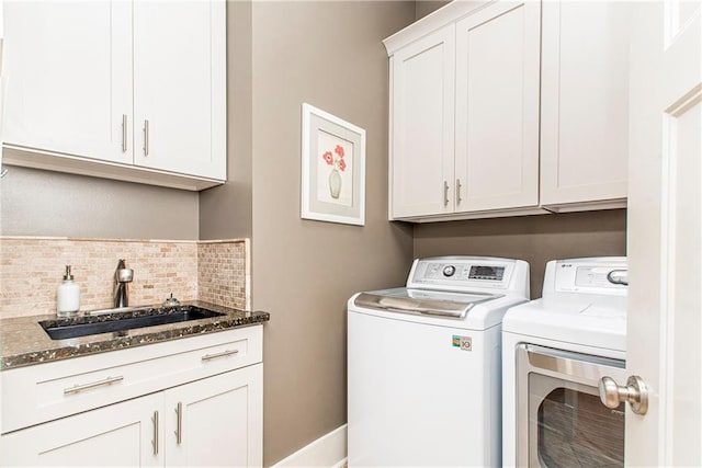 washroom featuring cabinets, sink, and washer and dryer