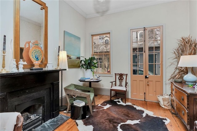 sitting room with crown molding and light wood-type flooring