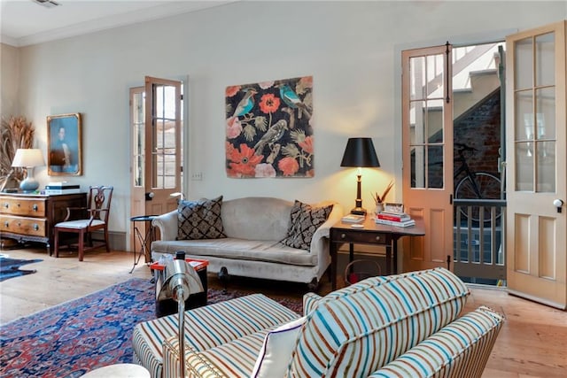 living room featuring crown molding and light hardwood / wood-style floors