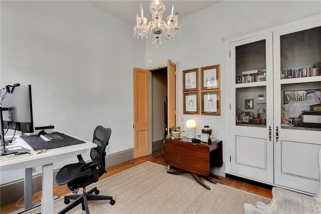 office space with light hardwood / wood-style flooring and a notable chandelier