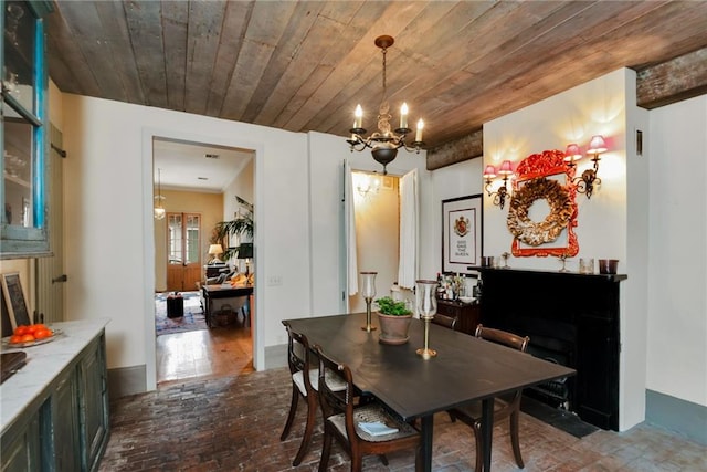 dining space with an inviting chandelier and wood ceiling