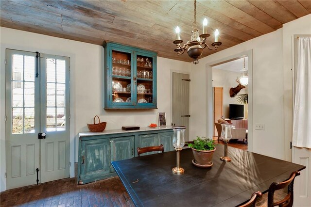 dining space with dark wood-type flooring, a notable chandelier, and wood ceiling